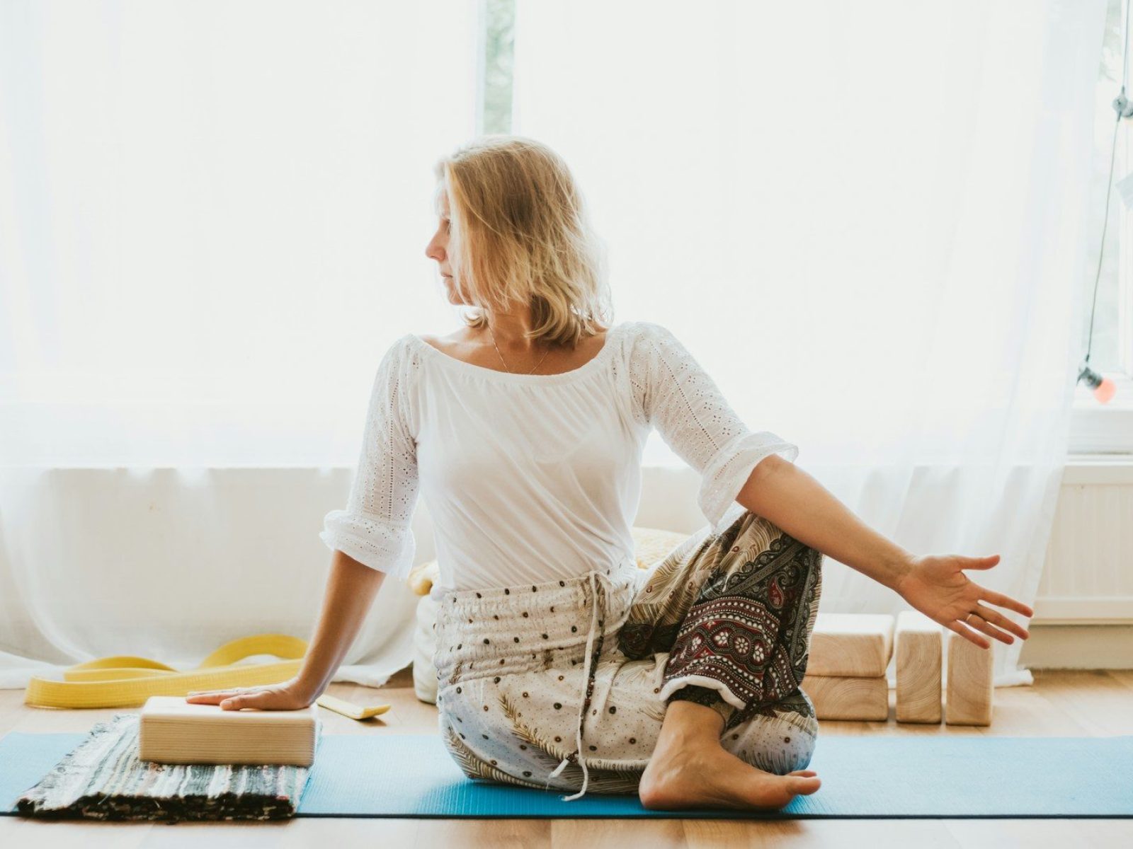 girl in white long sleeve shirt and blue pants sitting on white floor