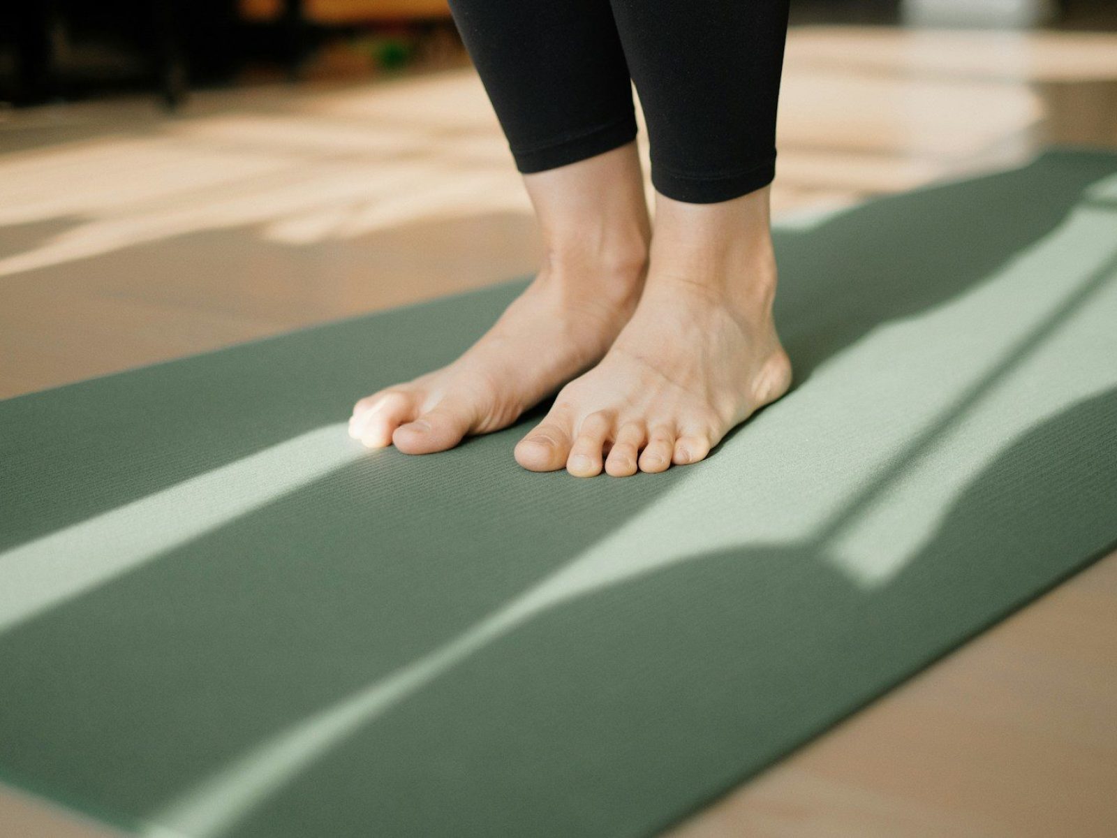 a person standing on a yoga mat on the floor
